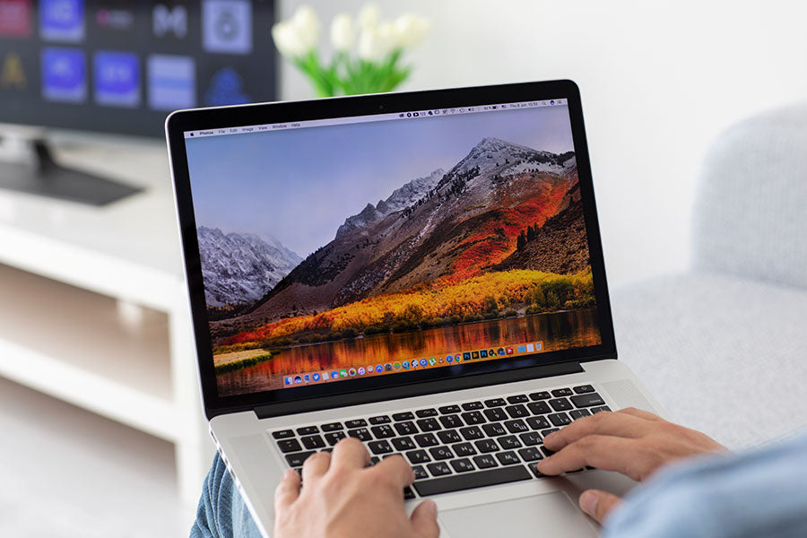 Customer reviewing MacBook Pro condition during in-store evaluation at PayMore Cumberland
